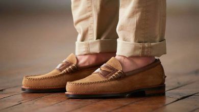 کفش کالج مردانه را با چه لباسی ست کنیم؟ 5 پاهای یک مرد با شلوار کتان کرم و کفش کالج قهوه ای، ایستاده روی پارکت