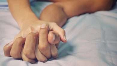 روی یک تخت با ملحفه سفید، دست خوابیده یک مرد در دست یک زن دیده می شود که نشان دهنده رابطه جنسی میان آنها است.