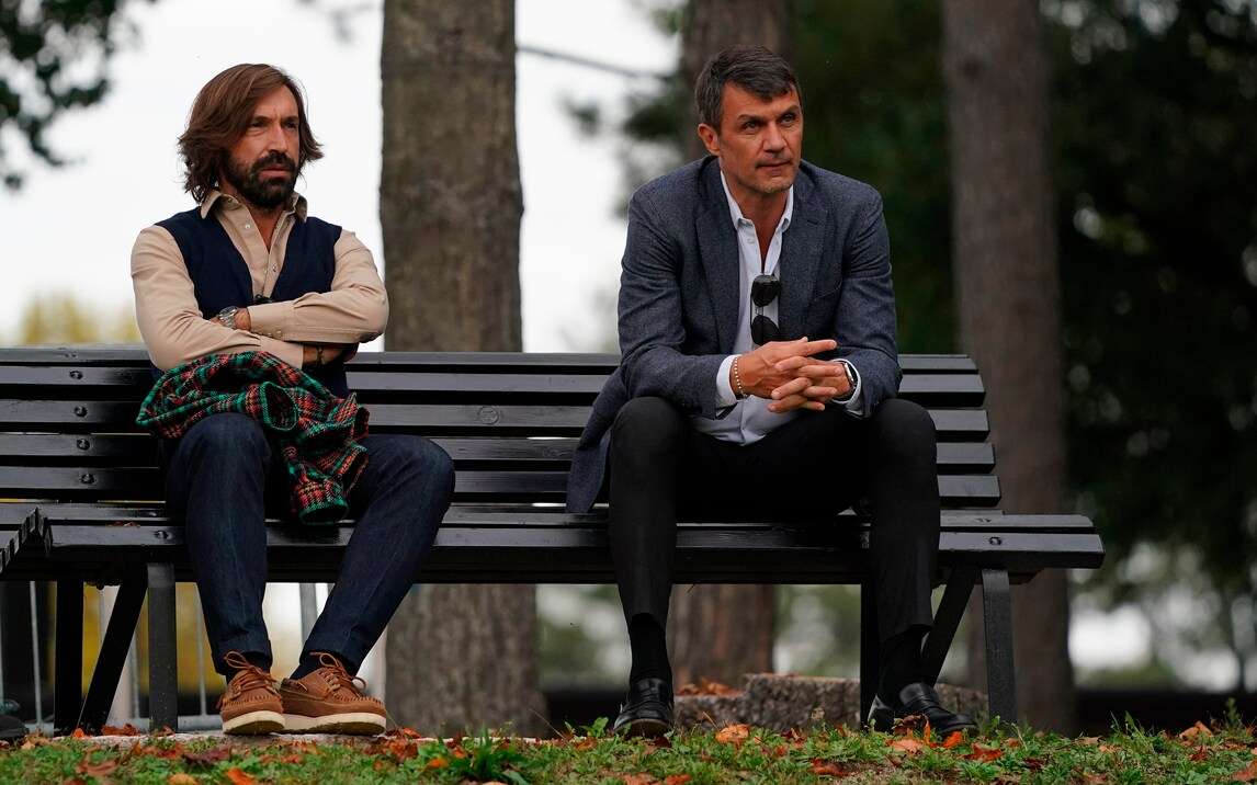 پائولو مالیدینی و آندره پیرلو با تیپ مردانه شیک خود روی یک نیمکت نشسته اند.