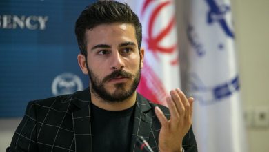 قهرمان سابق ایران، کیانوش رستمی، با پرچم کوزوو در مسابقات جهانی وزنه‌برداری